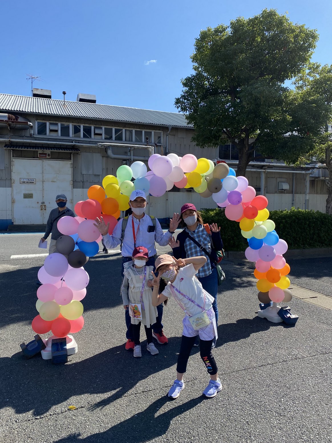 ウォークラリーのゴール地点で、風船のアーチをくぐり抜ける参加者たち